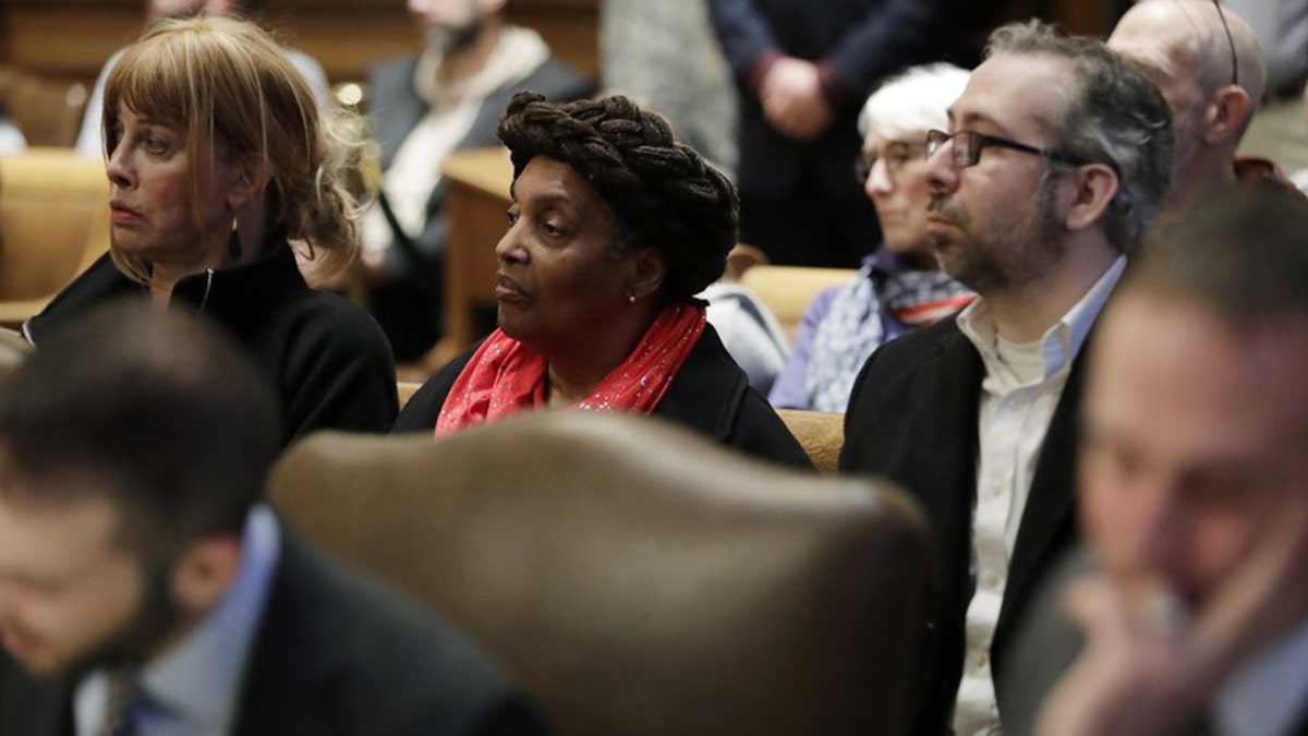 2016 Washington state presidential electors Esther John, center, and Bret Chiafalo, right, sit behind their attorneys Tuesday, Jan. 22, 2019, during a Washington Supreme Court hearing in Olympia, Wash., on a lawsuit addressing the constitutional freedom of electors to vote for any candidate for president, not just the nominee of their party. (AP Photo/Ted S. Warren)