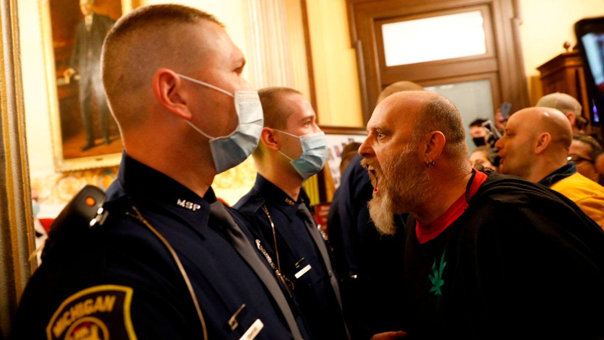 Protestors tried to enter the Michigan House of Representative chamber and were being kept out by the Michigan State Police at the State Capitol in Lansing,  on April 30. The group was upset with Michigan Gov. Gretchen Whitmer's mandatory closure to curtail Covid-19. (JEFF KOWALSKY/AFP via Getty Images)