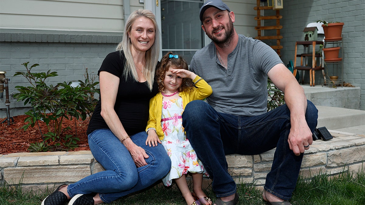 Eli Oderberg with wife Katie Evers and their 4-year-old daughter, Everlee, outside their home in southeast Denver last week. (AP Photo/David Zalubowski)