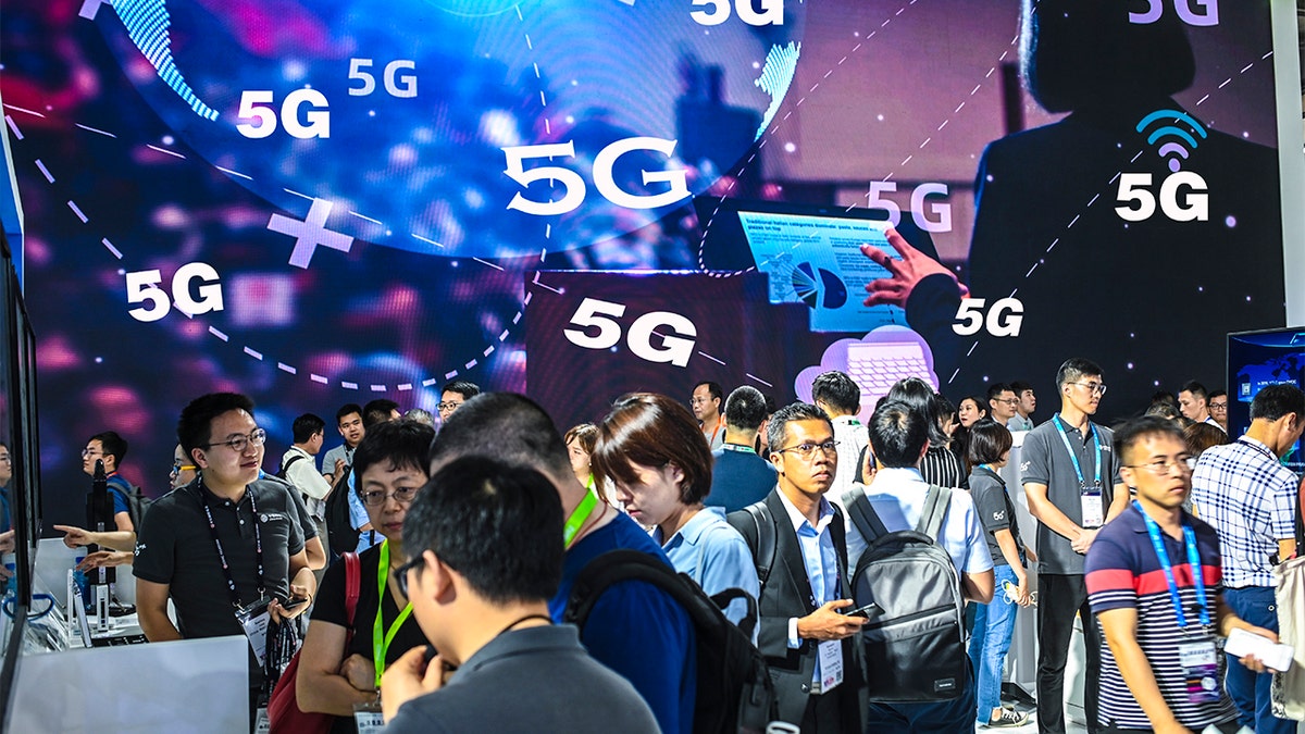 Visitors in action in front of a 5G advertisement during Mobile World Congress (MWC) Shanghai 2019 at Shanghai New International Expo Center on June 27, 2019 in Shanghai, China. (Photo by Gao Yuwen/Visual China Group via Getty Images)