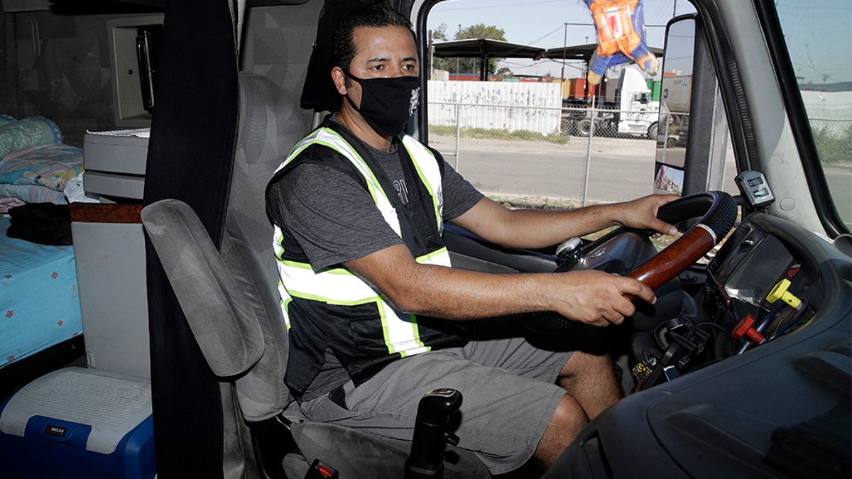 Juan Giraldo, a truck driver, inside his cab in Wilmington, Calif., last month. (AP Photo/Marcio Jose Sanchez)