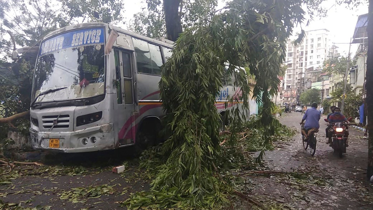 Commuters move past a tree branch precariously hanging after cyclone Amphan hit the region, in Kolkata, India, May 21. A powerful cyclone that slammed into coastal India and Bangladesh has left damage difficult to assess Thursday. (AP Photo/Bikas Das)