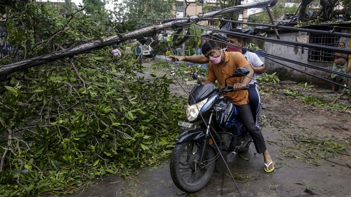 Motorists make their way through damaged cables and a tree branch fallen in the middle of a road after Cyclone Amphan hit the region in Kolkata, India, May 21. (AP Photo/Bikas Das)