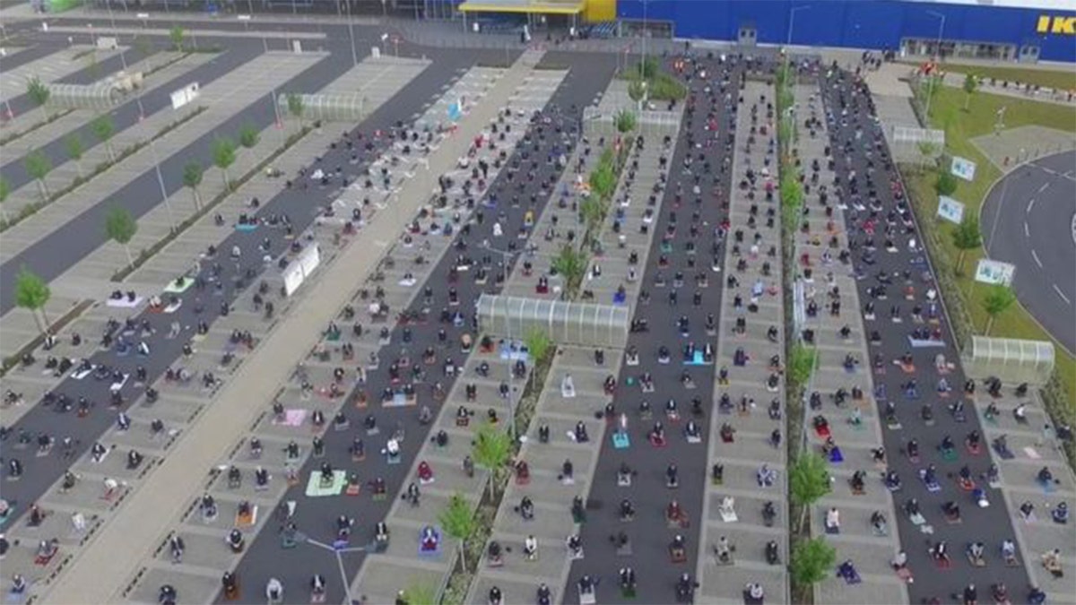 Muslims social distancing while using an Ikea parking lot for prayer. 