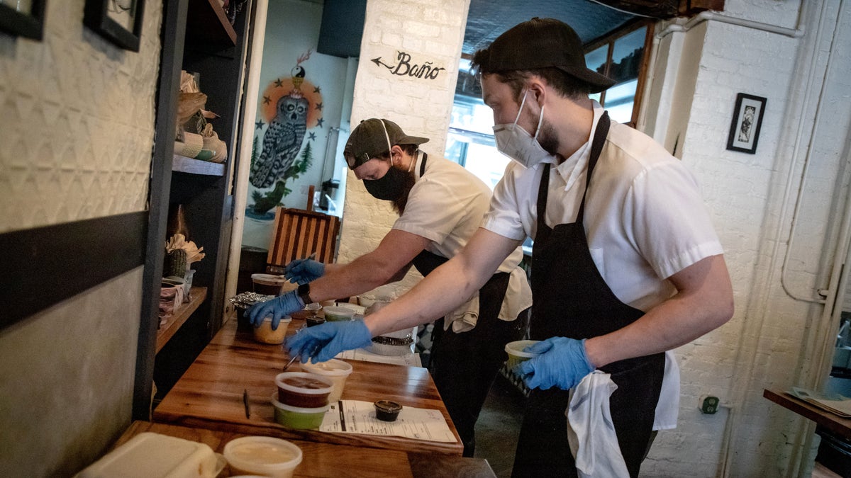 Cook Lincoln Clevenson and sous chef Austin Ishibashi manage takeout orders at Claro on April 25, 2020 in the Brooklyn borough of New York City. Claro, a one-star restaurant in the Michelin Guide, is serving food as a take-out and delivery only amid the COVID-19 pandemic.