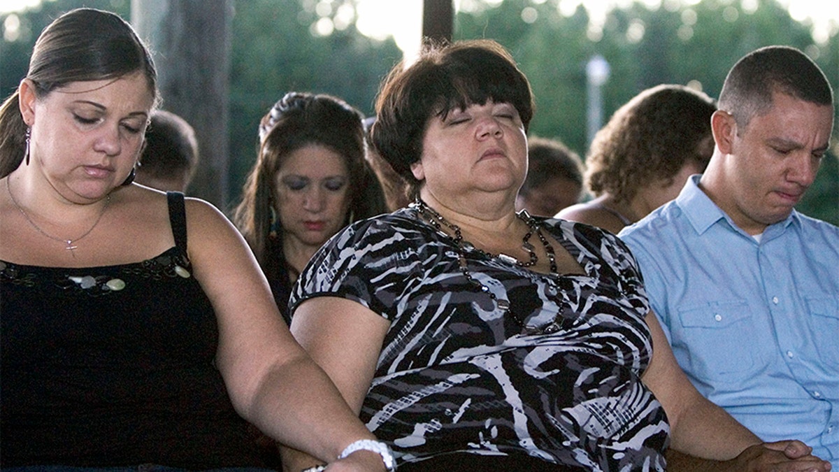 From left, Faith's sister Rolanda Hedgepeth, mother Connie Hedgepeth and cousin Jonathan Hedgepeth join other family, friends and community members at a candlelight vigil at the Haliwa-Saponi Tribal School in Hollister, North Carolina, to remember and pray for Faith Hedgepeth.