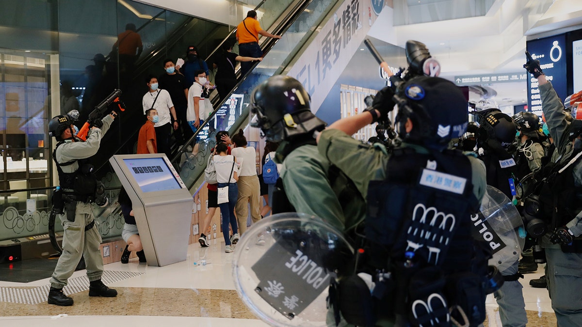 Riot police raise their pepper spray projectile inside a shopping mall as they disperse anti-government protesters during a rally, in Hong Kong, China, on Sunday. (Reuters)