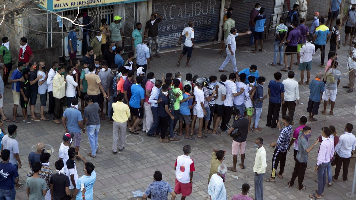 Indians line up without maintaining physical distance to buy liquor on the outskirts of Mumbai on Monday. (AP)