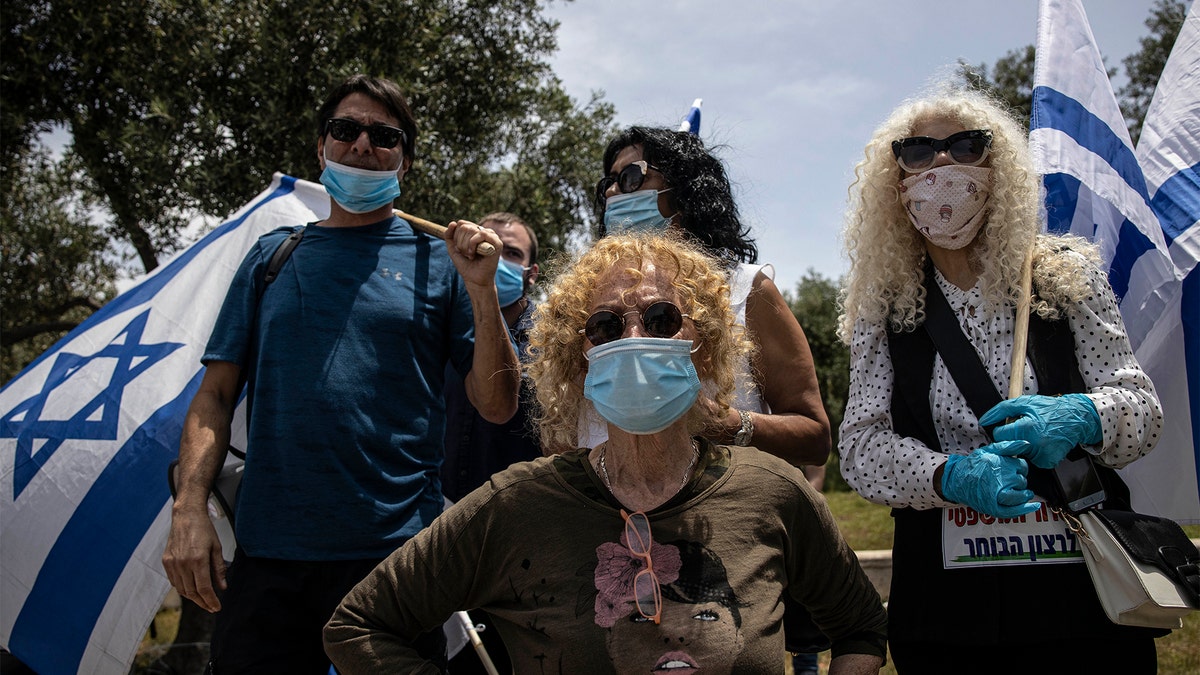 Supporters of Prime Minister Benjamin Netanyahu wear a masks amid concerns over the country's coronavirus outbreak during a protest by in front of Israel's Supreme Court in Jerusalem, Sunday, May 3, 2020.  (AP Photo/Tsafrir Abayov)