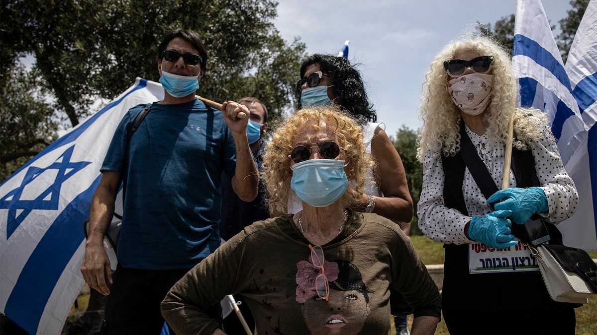 Supporters of Prime Minister Benjamin Netanyahu wear a masks amid concerns over the country's coronavirus outbreak during a protest by in front of Israel's Supreme Court in Jerusalem, Sunday, May 3, 2020. (AP Photo/Tsafrir Abayov)