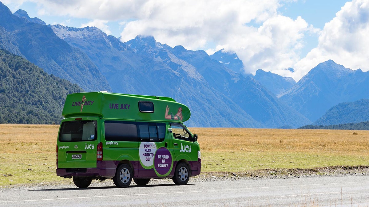 Jucy's famous green van driving through New Zealand.