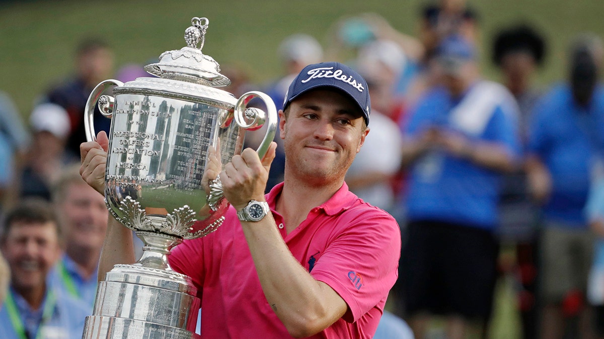 Justin Thomas poses with the Wanamaker Trophy after winning the PGA Championship golf tournament at the Quail Hollow Club in Charlotte, North Carolina, on Aug. 13, 2017.