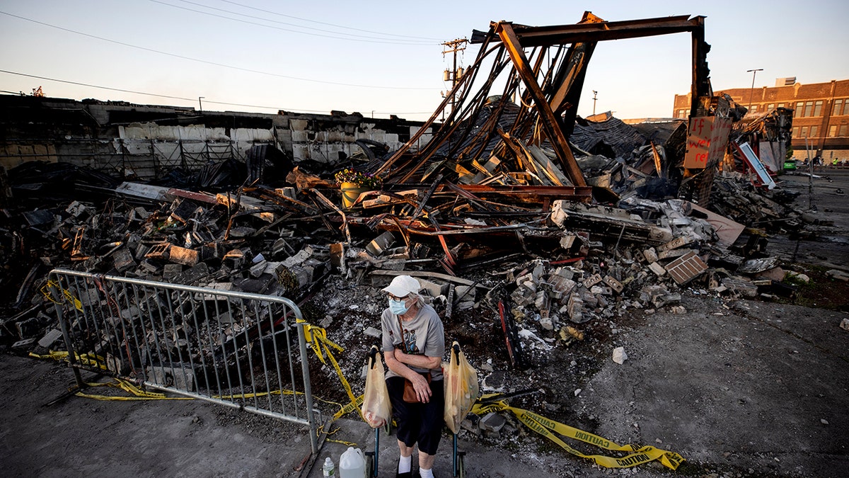 Sandra King, 70, waits for her granddaughter near the remains of AutoZone across from the Minneapolis 3rd Police Precinct in Minneapolis on May 28. (Carlos Gonzalez/Star Tribune via AP)