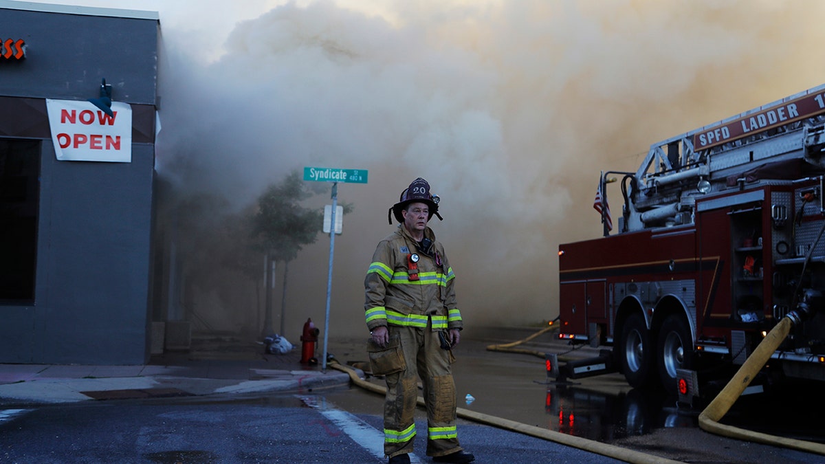 A firefighter pauses on Thursday, May 28, 2020, the third straight day of protests in St. Paul, Minn. (AP Photo/Julio Cortez)