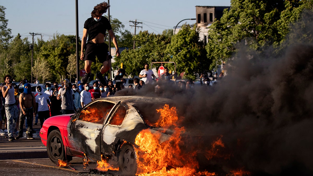 A car burns in a Target parking lot Thursday, May 28, 2020, in Minneapolis. (Carlos Gonzalez/Star Tribune via AP)