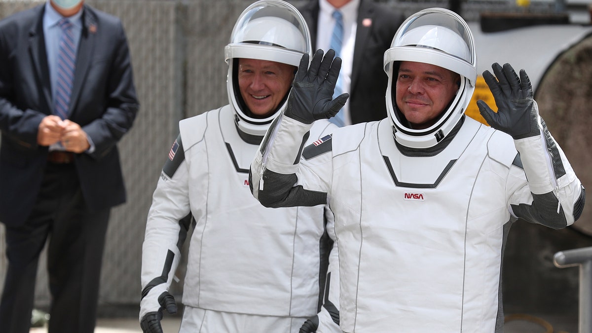 NASA astronauts Bob Behnken (R) and Doug Hurley (L) walk out of the Operations and Checkout Building on their way to the SpaceX Falcon 9 rocket with the Crew Dragon spacecraft on launch pad 39A at the Kennedy Space Center on May 27, 2020 in Cape Canaveral, Florida.