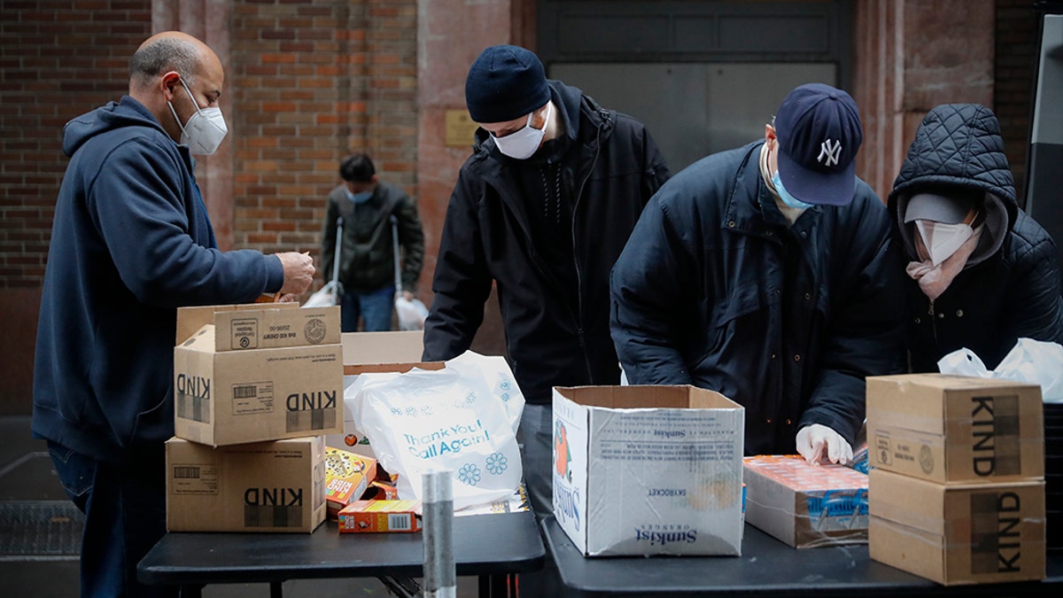In this Friday, April 24, 2020, photo, workers prepare bags of donated food for people in need through the Coalition for the Homeless organization at St. Bartholomew's Episcopal Church in New York. (AP Photo/John Minchillo)