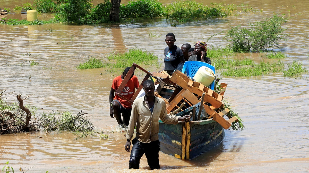 Residents use a boat to carry their belongings through the waters after their homes were flooded as the River Nzoia burst its banks and due to heavy rainfall and the backflow from Lake Victoria, in Budalangi within Busia County, Kenya May 3, 2020.
