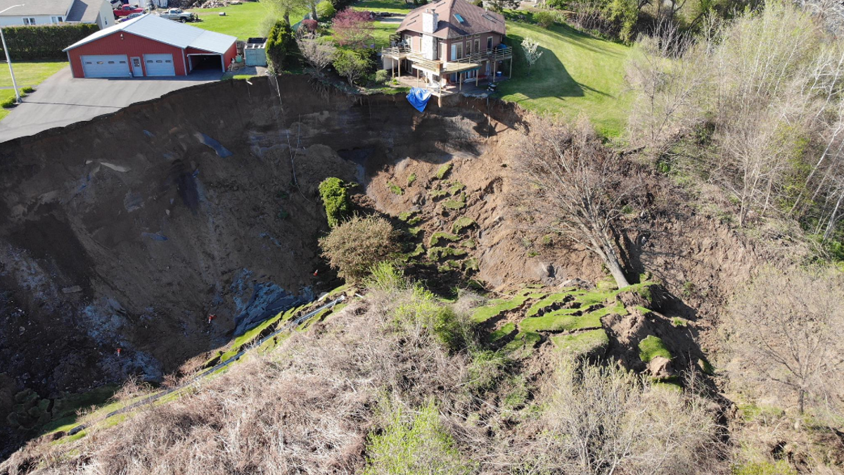 Drone footage shows a landslide in New York on Sunday that forced the evacuation of several residents and left homes dangling on the edge of a cliff.