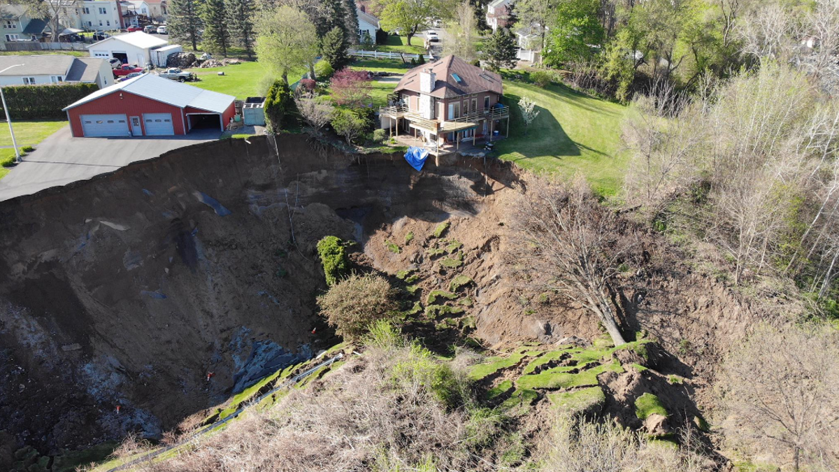 Drone footage shows a landslide in New York on Sunday that forced the evacuation of several residents and left homes dangling on the edge of a cliff.