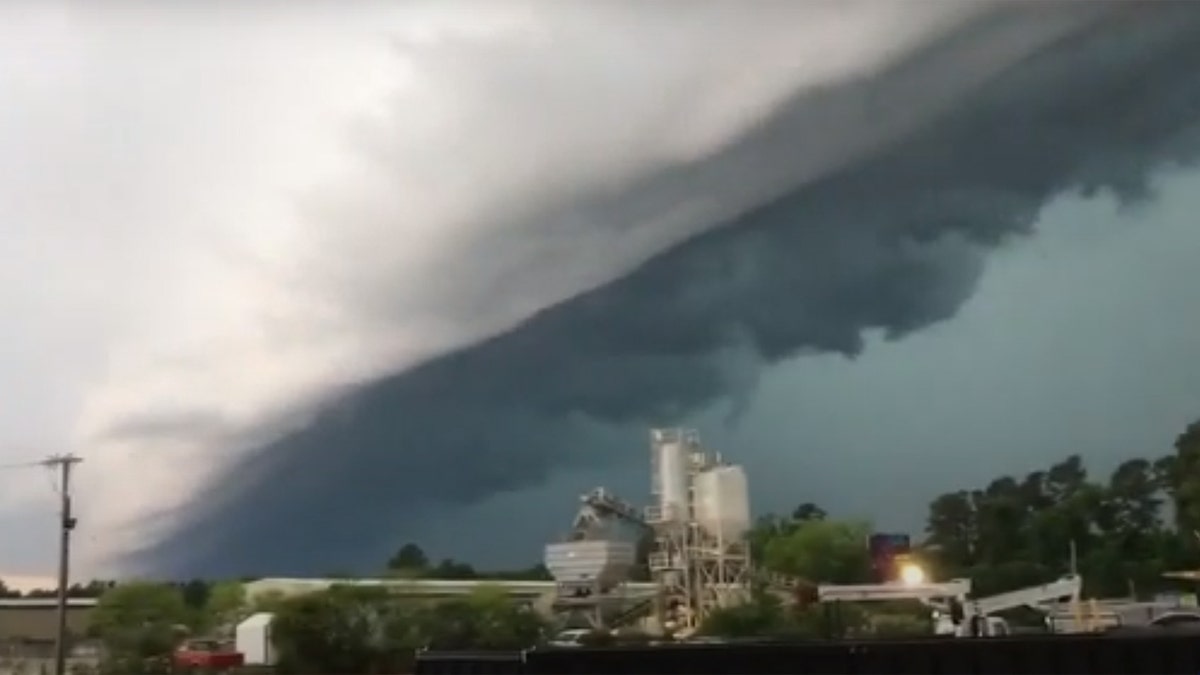 Storm clouds loom over an industrial area in Conway, South Carolina, on Tuesday as lightning flashes in the distance as severe thunderstorms impacted the state.