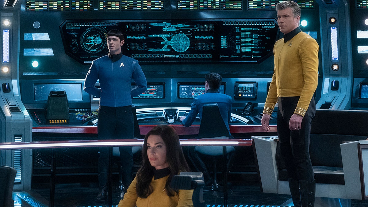 This image released by CBS All Access shows, from left, Ethan Peck as Spock, Rebecca Romijn as Number One, and Anson Mount as Captain Pike of the the CBS All Access series "Star Trek: Strange New Worlds." CBS All Access is bringing back Spock for its third full live action show in the "Star Trek" universe, ordering a new series set in the years before Capt. James T. Kirk helmed the U.S.S. Enterprise. (Michael Gibson/CBS via AP)