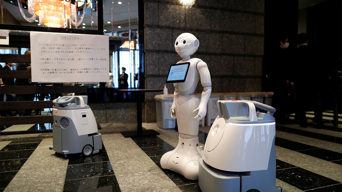 A Pepper humanoid robot, manufactured by SoftBank Group Corp. and cleaning robot Whiz are seen during a press preview at a hotel of APA Group that has been designated to accommodate asymptomatic people and those with light symptoms of the coronavirus disease (COVID-19) to free up hospital beds and alleviate work by nurses and staff members, in Tokyo, Japan May 1, 2020.