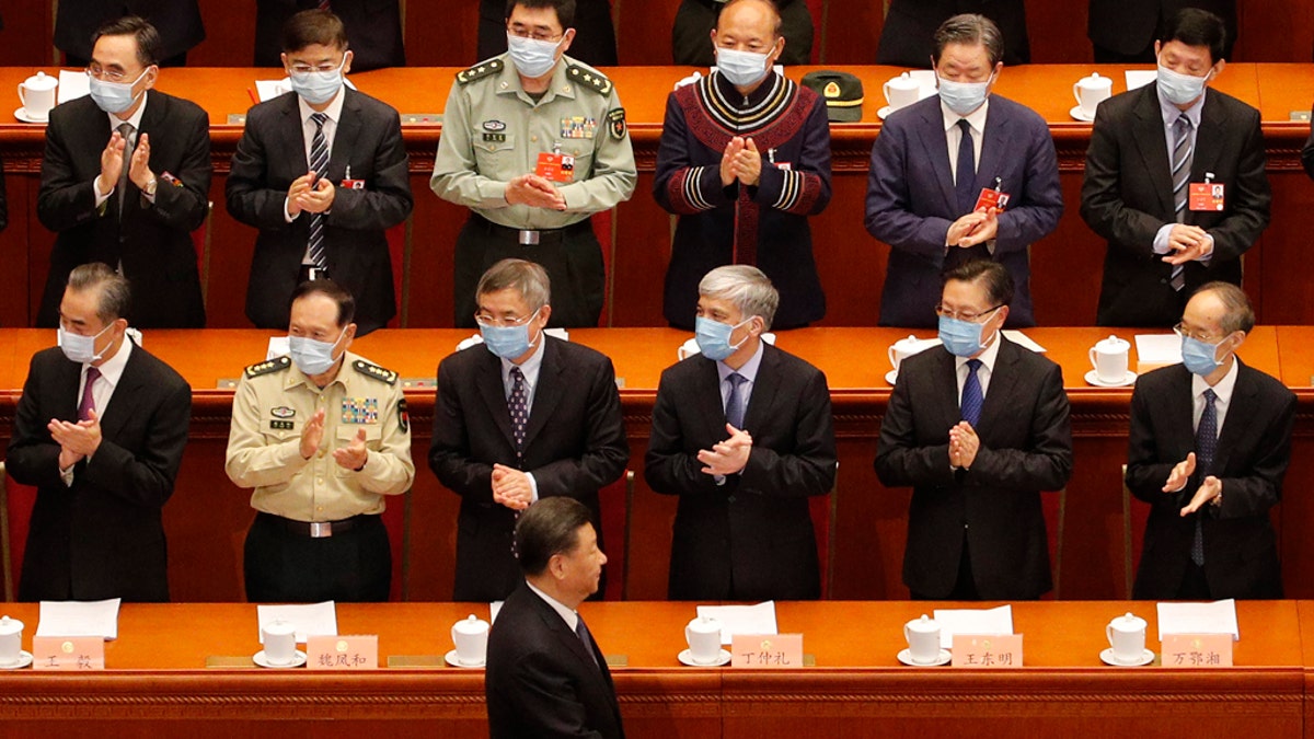 Delegates wearing face masks to protect against the spread of the new coronavirus applaud as Chinese President Xi Jinping arrives during the opening session of the Chinese People's Political Consultative Conference (CPPCC) at the Great Hall of the People in Beijing, Thursday, May 21, 2020. (AP Photo/Andy Wong, Pool)