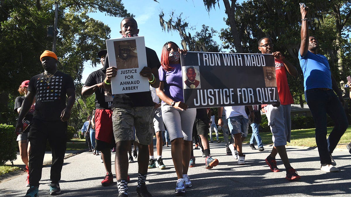 In this Tuesday, May 5, 2020, photo, a crowd marches through a neighborhood in Brunswick, Ga. They were demanding answers in the death of Ahmaud Arbery. An outcry over the Feb. 23 shooting of Arbery has intensified after cellphone video that lawyers for Arbery's family say shows him being shot to death by two white men. (Bobby Haven/The Brunswick News via AP)