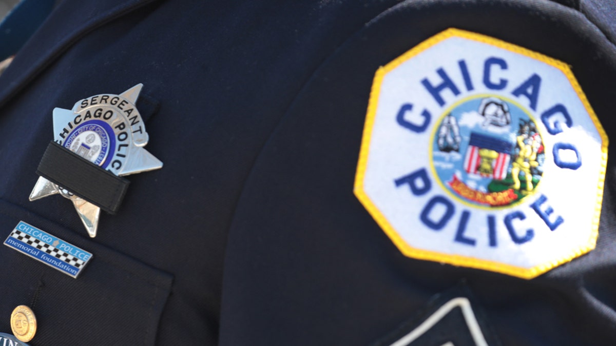 A police officer wears a button with a picture of Sgt. Clifford Martin, a 25-year veteran of the Chicago Police Department, while attending his funeral on April 21 in Chicago. Martin died on April 10, from complications from COVID-19. In accordance with the social distancing restrictions imposed by the state, only 10 family members were allowed inside the funeral home for the service and police officers joining in the procession were asked to remain in their cars outside of the funeral home during the service. (Photo by Scott Olson/Getty Images)