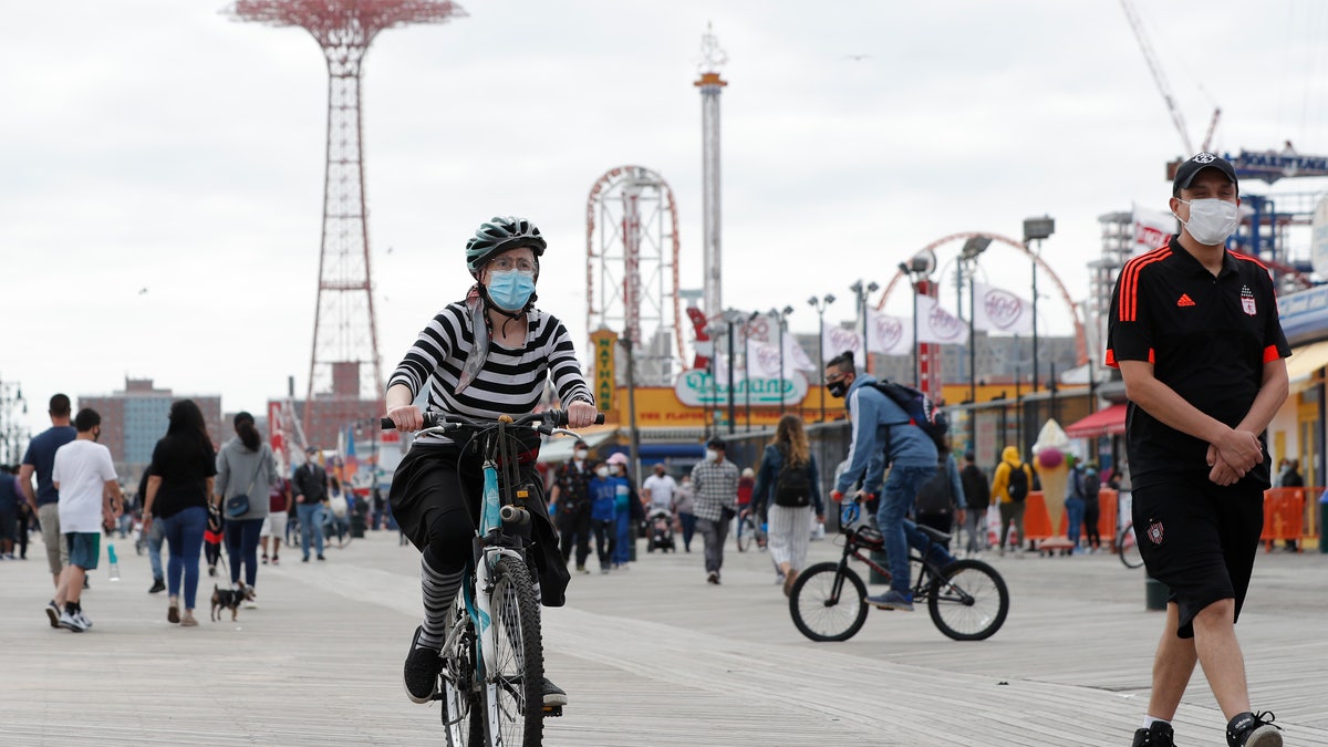 A woman rides her bicycle on the boardwalk at Brooklyn's Coney Island during the Memorial Day weekend. (AP)