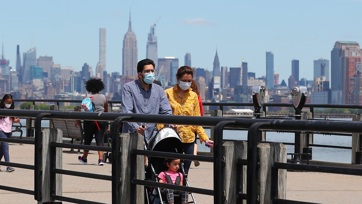A general view of people wearing masks walking on the promenade as New Jersey continues with its Phase 1 of reopening the state during the Coronavirus (COVID-19) pandemic on May 16, 2020, at Liberty State Park in Jersey City, NJ.