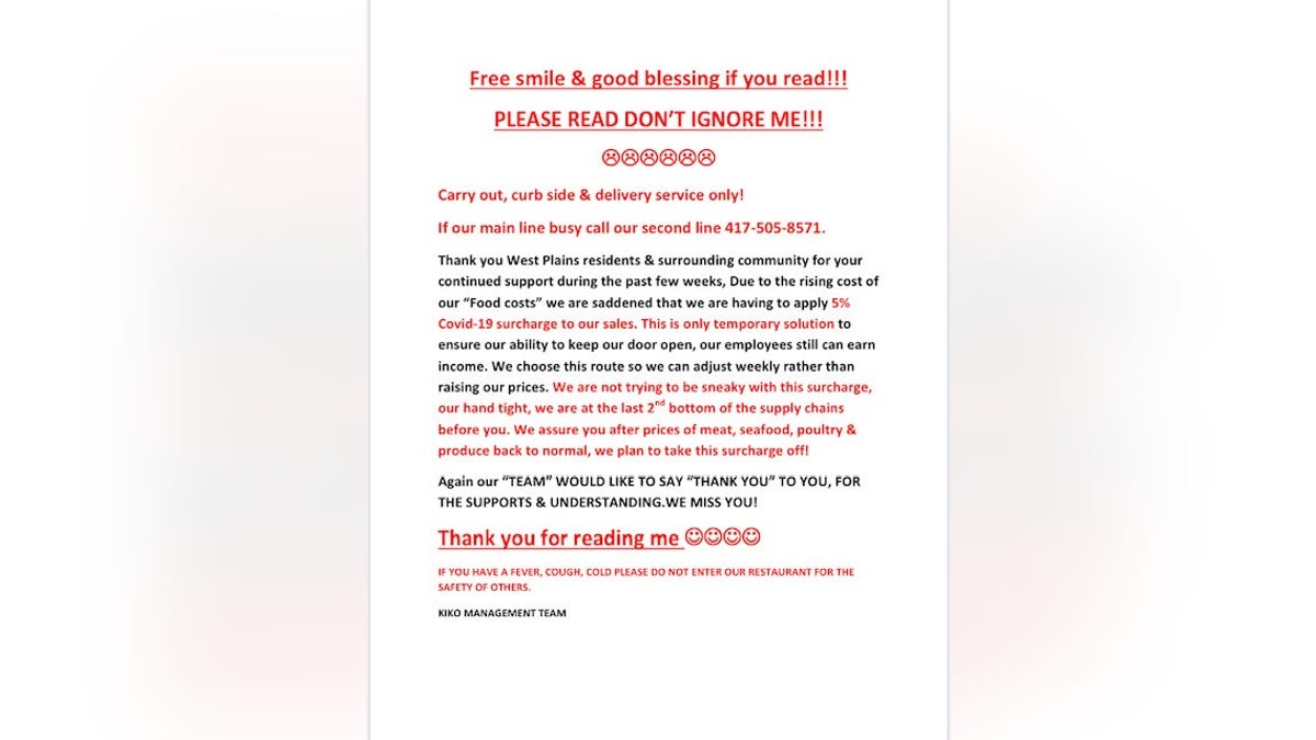 Billy Yuzar posted this notice on the door and register of his restaurant, to inform his customers of the surcharge.