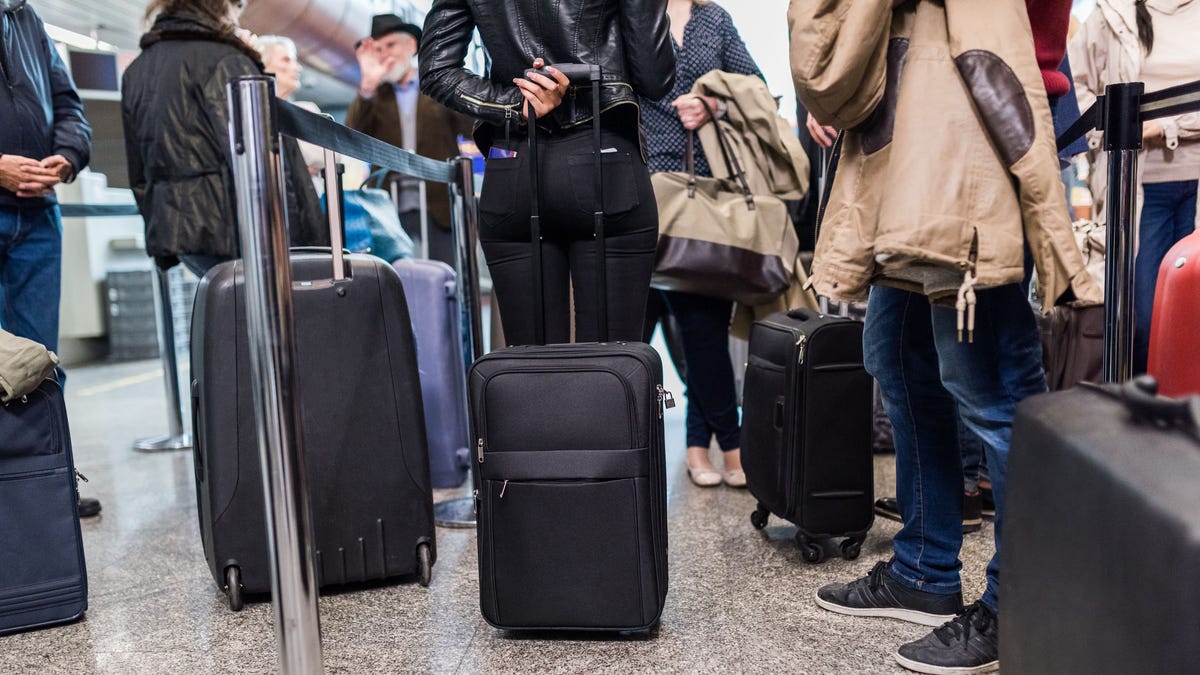 Group Of People Standing In Queue At Boarding Gate