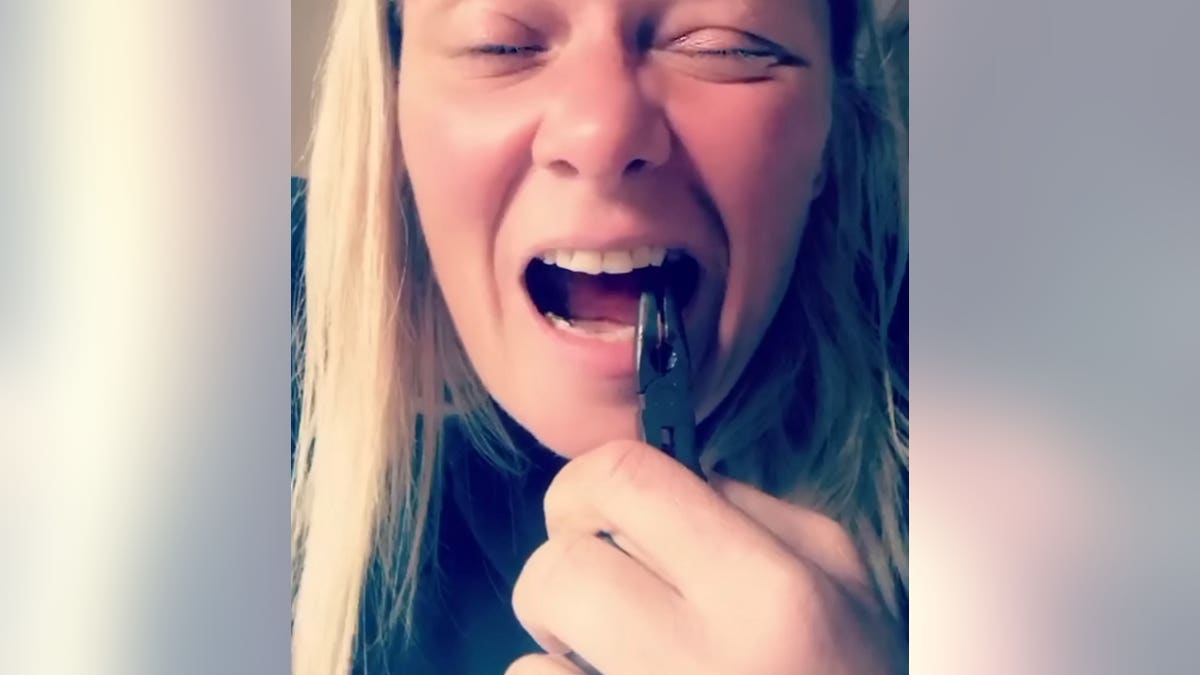 Fay Rayward attempting to pull her tooth out on her Facebook video.