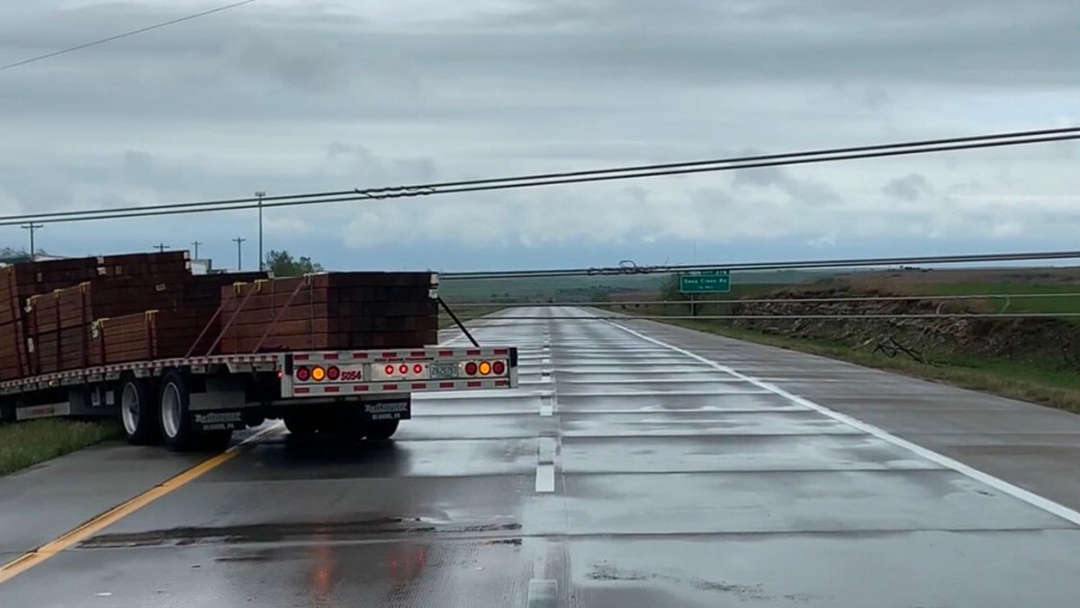 A semi-truck nearly hit power lines that were knocked down by a severe thunderstorm in Kansas on Monday.
