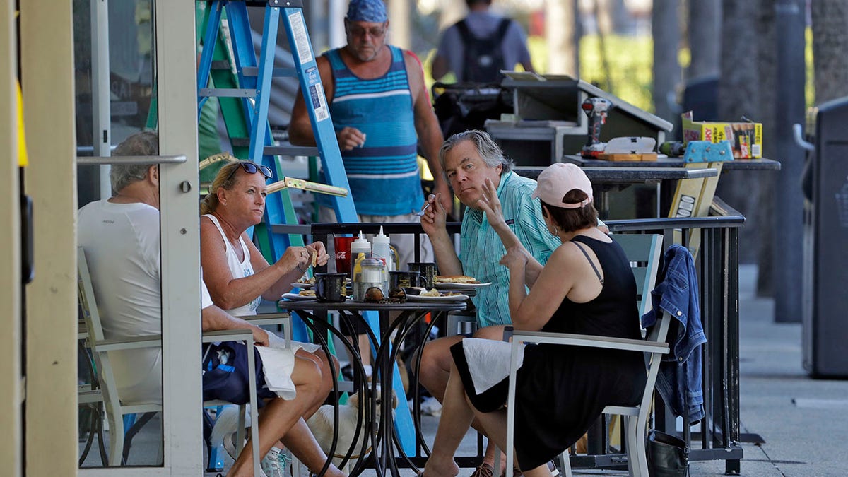 People have breakfast at a cafe Monday in Clearwater Beach, Fla., as many public beaches and restaurants begin reopening. (AP Photo/Chris O'Meara)