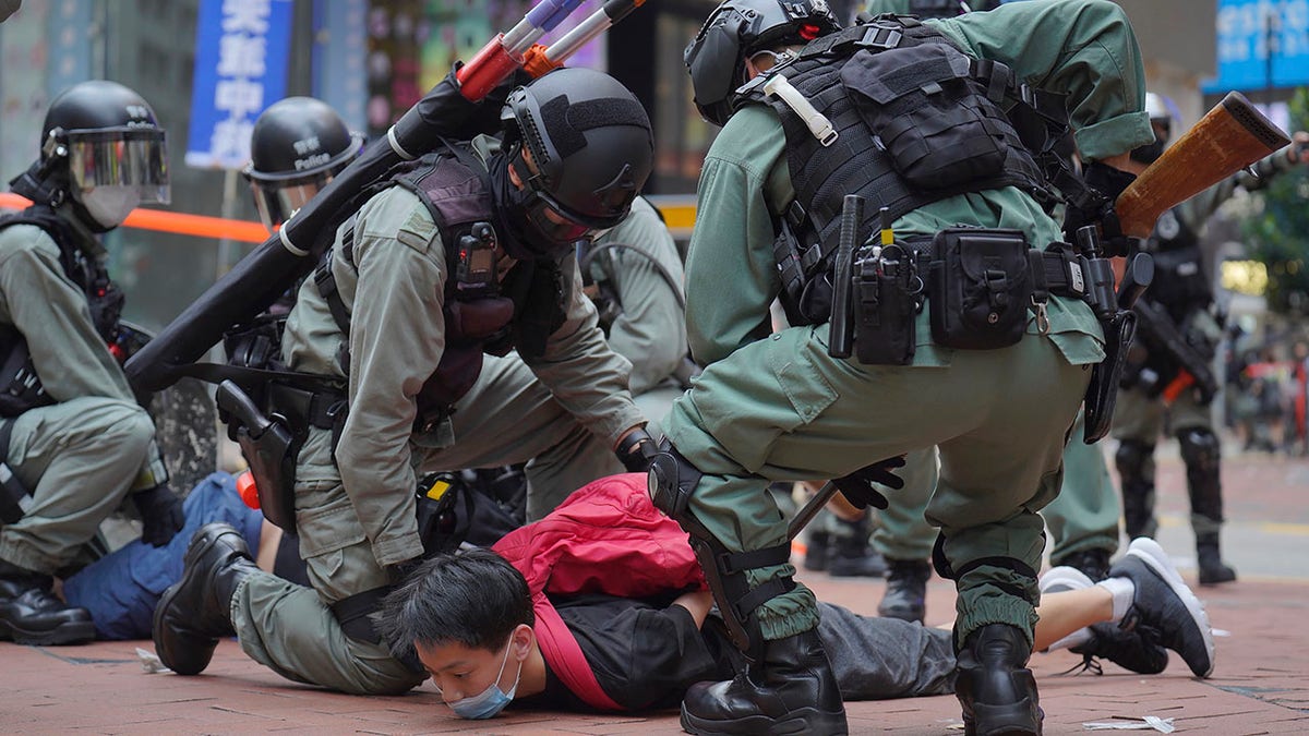 Riot police detain a protester during a demonstration against Beijing's national security legislation in Causeway Bay in Hong Kong, Sunday, May 24, 2020. (AP Photo/Vincent Yu)