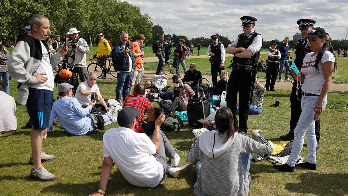 Police speak to people to break up a gathering during a mass gathering protest organised by the group called 'UK Freedom Movement', in Hyde Park in London as the country is in lockdown to help stop the spread of coronavirus, Saturday, May 16, 2020. The group claims that the coronavirus lockdown is illegal. (AP Photo/Kirsty Wigglesworth)