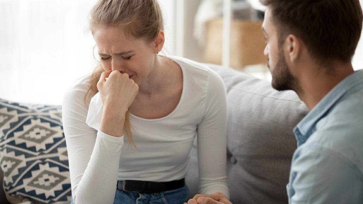 grieving woman supported by man