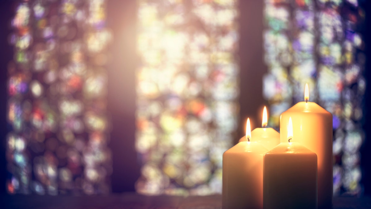 stained glass and a candle in a church