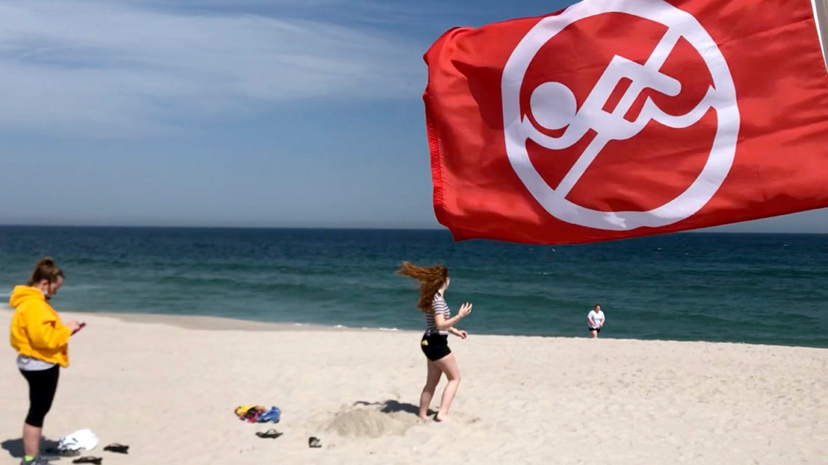 A 'no swimming' flag blows in the wind on the beach at Seaside Heights, N.J., on Friday, May 15, 2020, the first day it opened during the coronavirus outbreak. 