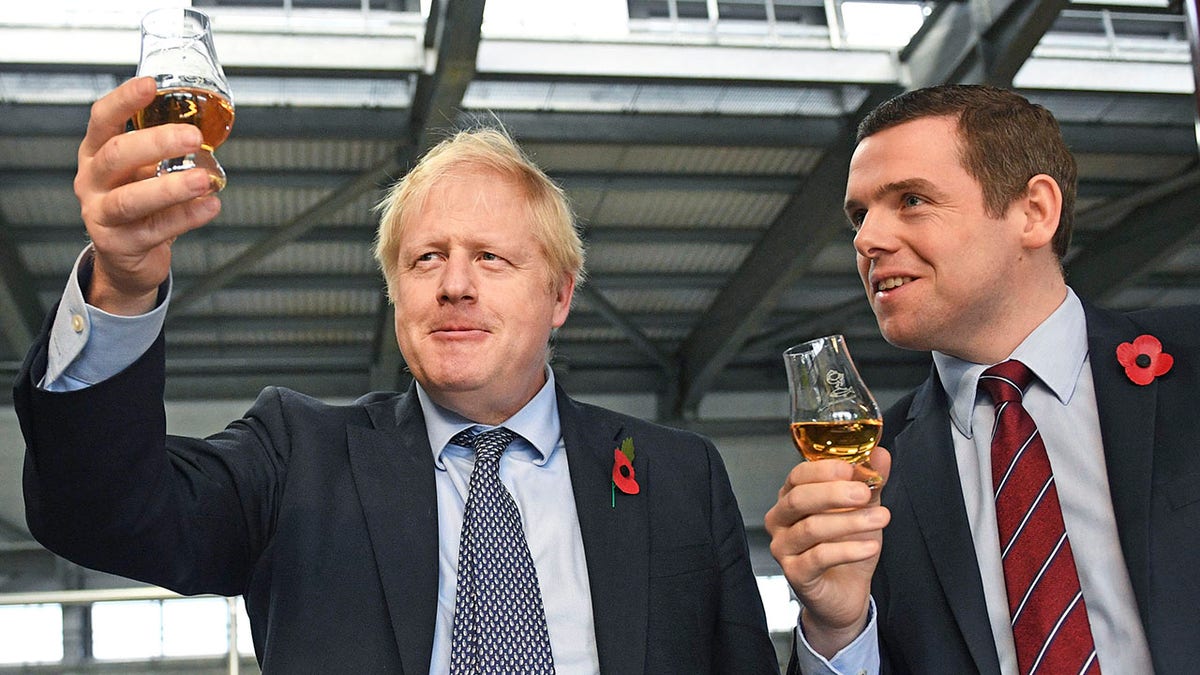 Junior British government minister Douglas Ross, right, has quit over Johnson’s failure to fire his top aide, Dominic Cummings, for allegedly breaching COVID-19 coronavirus lockdown rules. (Stefan Rousseau / PA via AP)