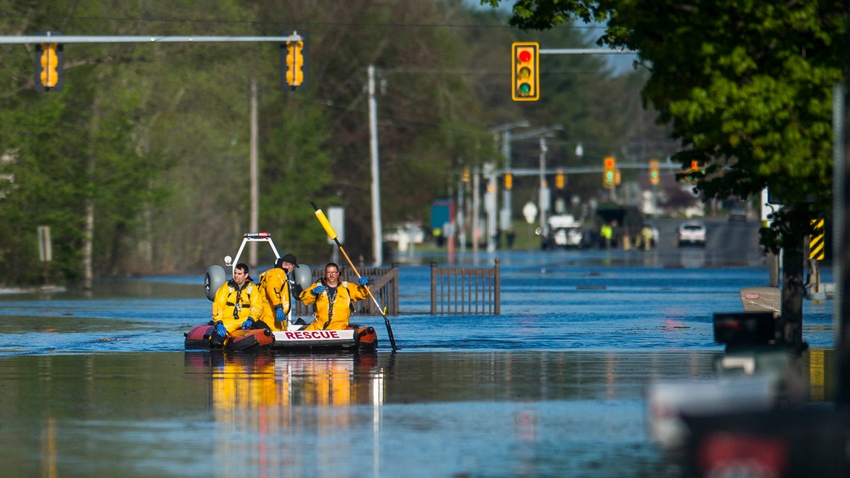 A search and rescue boat is deployed as Saginaw Road is closed at Drake due to water over the road while floodwater rises in Midland, Mich., May 20.