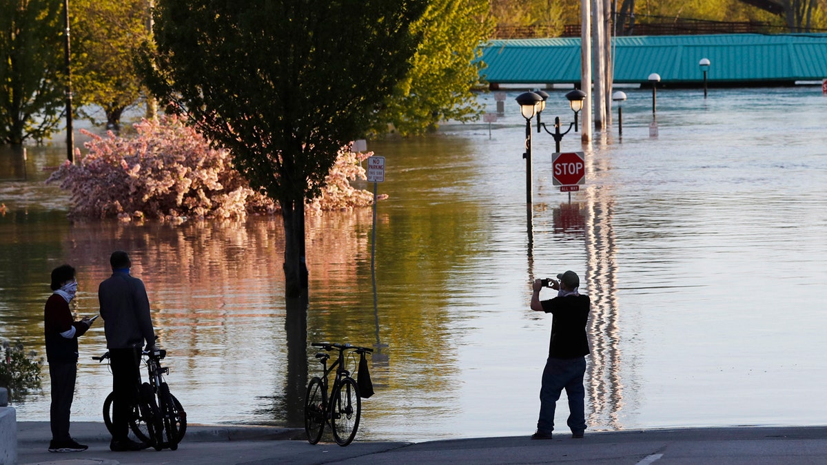 People photograph the floodwaters of the Tittabawassee River that encroached on downtown Midland, Mich., May 20.