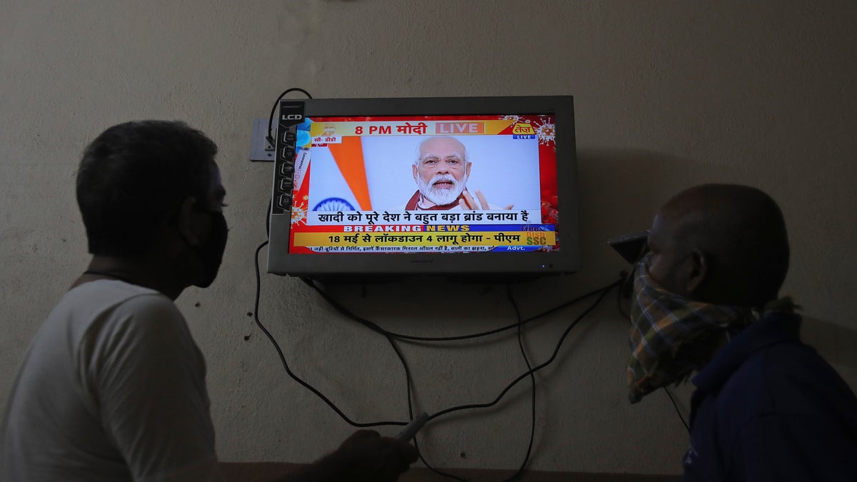 Indians watch a televised address to the nation by Prime Minister Narendra Modi in Hyderabad, India, on Tuesday. Modi announced that the government will spend the equivalent of nearly 10% of the country's GDP on a coronavirus virus economic relief package designed to make the world's second most populous nation more self reliant. (AP)