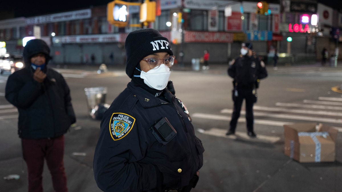 Police officers patrol a quiet street on foot April 22, during the coronavirus pandemic, in the Bronx borough of New York. As President Trump aims for a swift nationwide reopening, he faces a new challenge: convincing people it's safe to come out and resume their normal lives. (AP Photo/Mark Lennihan)