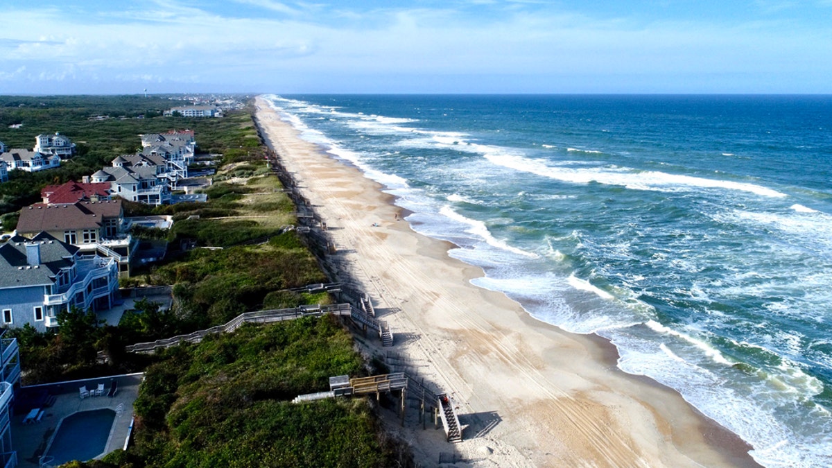 A man in North Carolina jumped into action after hearing screams on the beach and pulled two young girls from a rip current in the Outer Banks on Friday, according to officials.