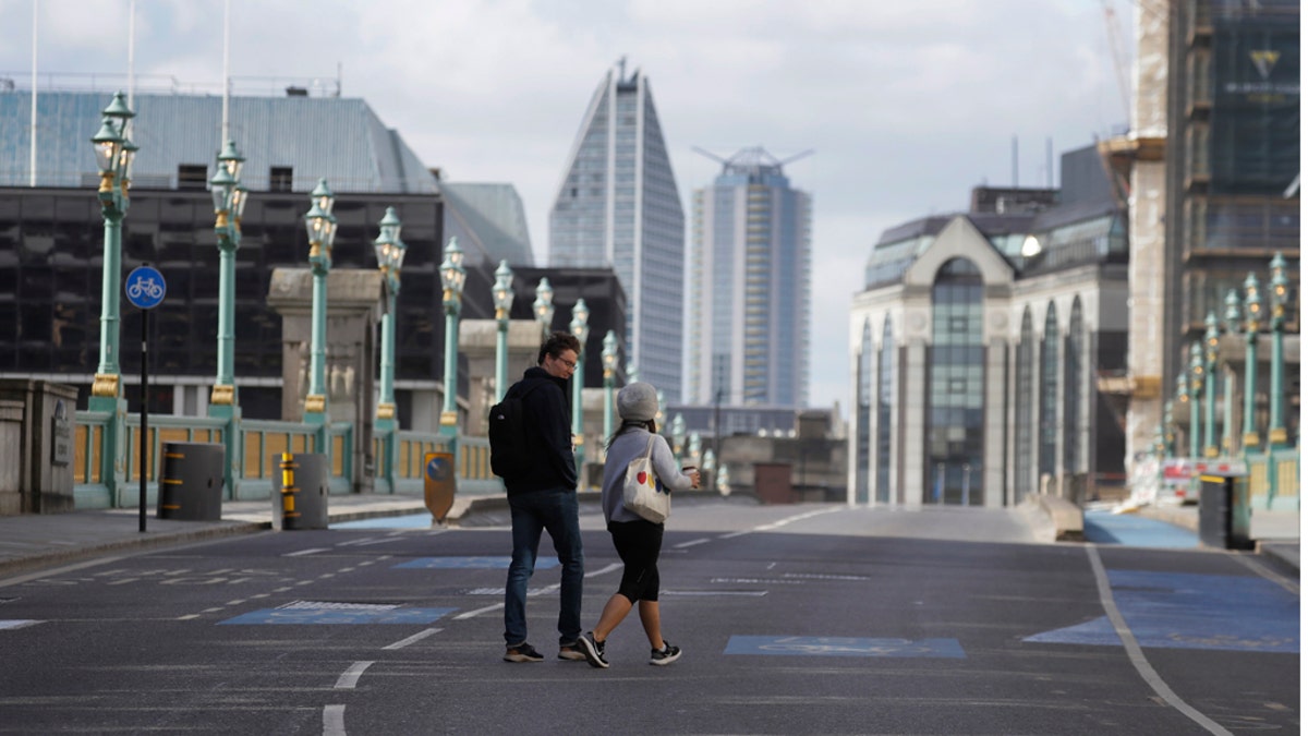 Pedestrians cross the road on Southwark Bridge during the morning rush hour in London as the country continues in lockdown to help stop the spread of coronavirus, Monday, May 11, 2020. Britain's Prime Minister Boris Johnson announced Sunday that people could return to work if they could not work from home. (AP Photo/Kirsty Wigglesworth)