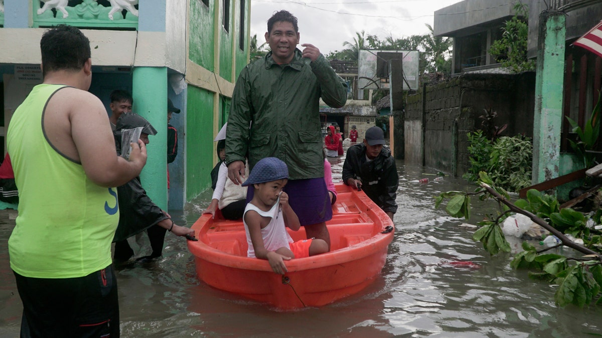 Residents ride a boat along a flooded village as typhoon Vongfong passes by Sorsogon province, northeastern Philippines on Friday May 15, 2020. 